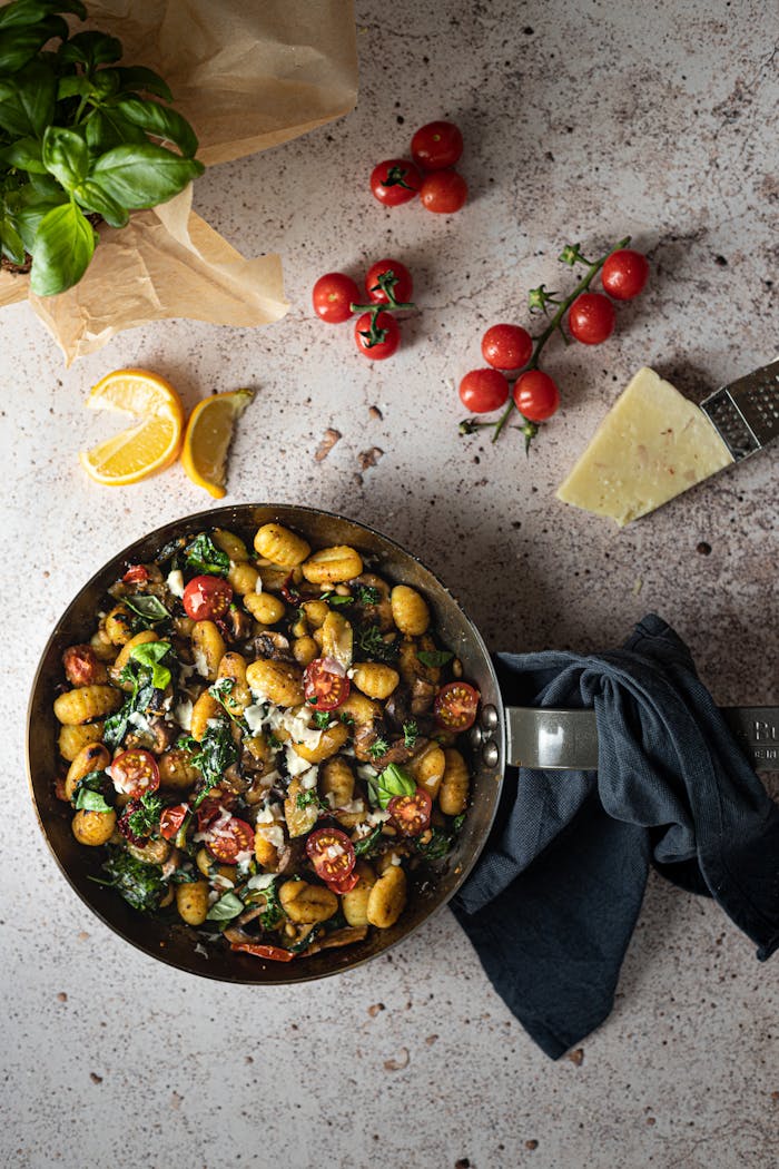 Delicious gnocchi with fresh basil, cherry tomatoes, and cheese in a rustic setting.